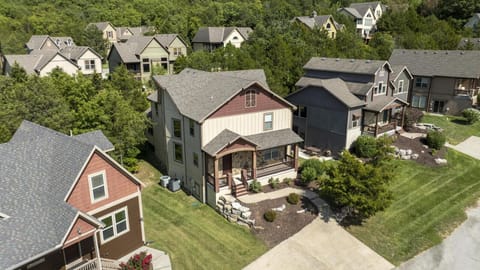 Charming two-story home surrounded by trees and neighboring cottages in a serene vacation community.