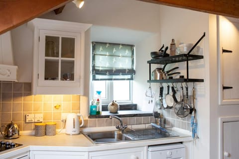 Kitchen with dishwasher, kettle and plenty of cooking utensils