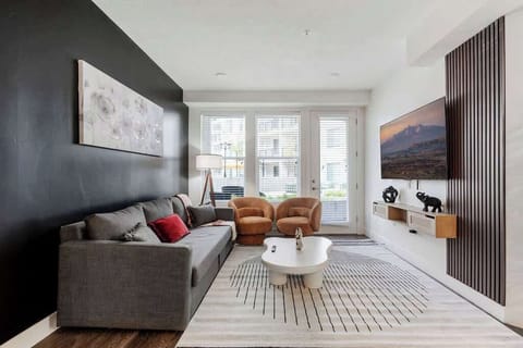 Enjoy a movie night in this inviting living room, featuring a TV, comfy sofas, and an artistic center table.