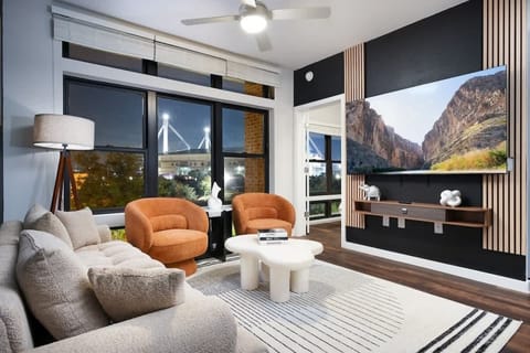 Bright and inviting, our living room features a beautiful painting, comfy sofas, and a refreshing plant.