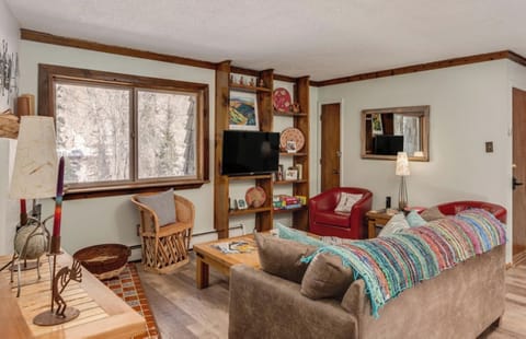 Curl up on the cozy sofa, enjoy a peaceful view of the trees, and feel completely at home in this welcoming space with warm wood accents and thoughtful decor.