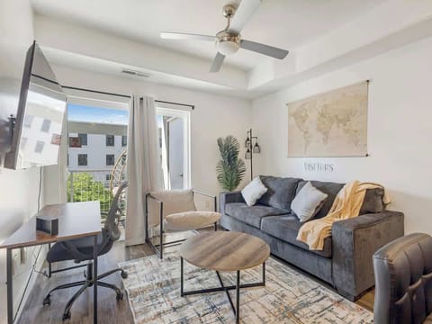 Bright living area w/ sofa, desk workspace & balcony access for fresh air