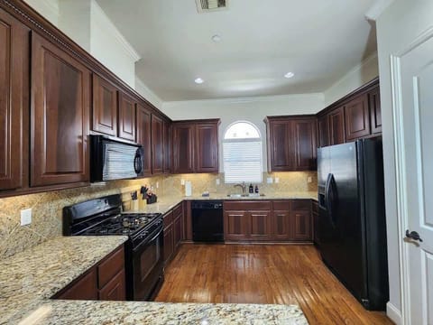 Sleek kitchen with white cabinets and stainless steel appliances.
