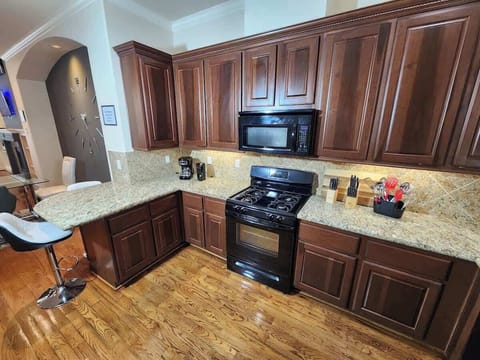Gourmet kitchen with rich wood and polished granite finishes.
