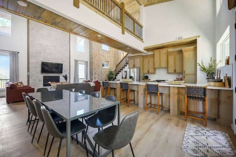 Open-concept kitchen and dining area with modern appliances, wood accents, and ample seating.