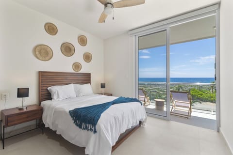 Bedroom 1: Cozy queen bed, soft linens, and private ocean-view balcony.