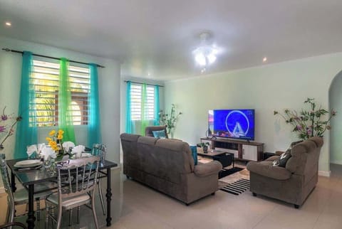 Experience the perfect blend of comfort & style in this open-concept living room. Enjoy your favorite shows on a 65" flat screen TV with Amazon Fire Stick, dimmable lights, stunning island artwork, cozy seating, ocean breezes, and family board games!