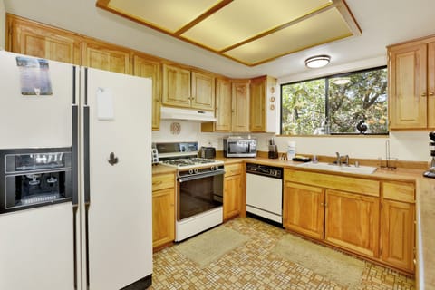 Fully equipped cabin kitchen with ample cabinetry, stove, fridge, microwave, and coffee maker—perfect for cooking meals, morning coffee, and feeling right at home on your stay.