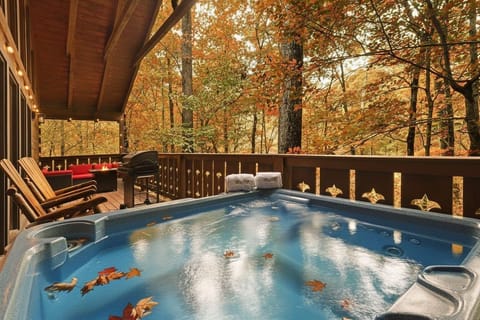 Relax in the hot tub on the rustic covered deck surrounded by autumn foliage.