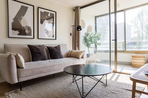 Bright and stylish living area with modern decor and balcony access, perfect for relaxation.