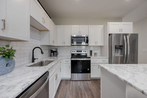 Full kitchen with stainless steel appliances and breakfast bar with seating for 3