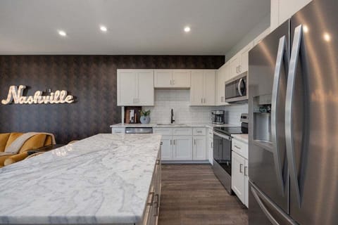 Full kitchen with stainless steel appliances and breakfast bar with seating for 3