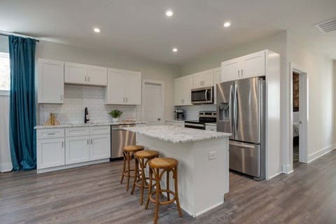 Full kitchen with stainless steel appliances and breakfast bar with seating for 3