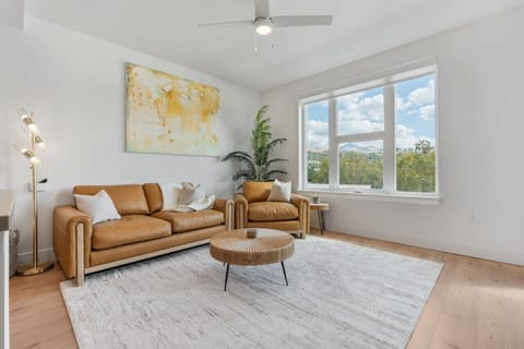 Beautifully designed living room. 65` TV, leather sofa and amazing views of mountains and city skyline.