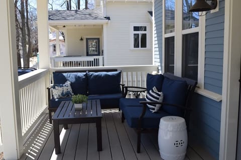 Deck lounge chairs on porch with pool across the street