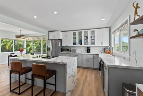 Modern and spacious, this fully equipped kitchen features sleek countertops and a breakfast bar.