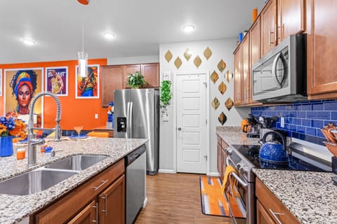 A spacious, fully-equipped kitchen featuring a sleek sink, modern appliances, and ample counter space, designed for convenience and efficiency