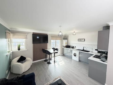 Recently upgraded open-plan living space with modern kitchen, breakfast bar and comfortable lounge area — perfect for relaxing or socialising.