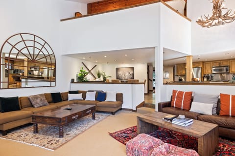 - Spacious living room with rustic cabin inspired design  
- Cozy seating, fireplace, and warm mountain retreat style  
- Open layout connecting kitchen, dining, and living areas