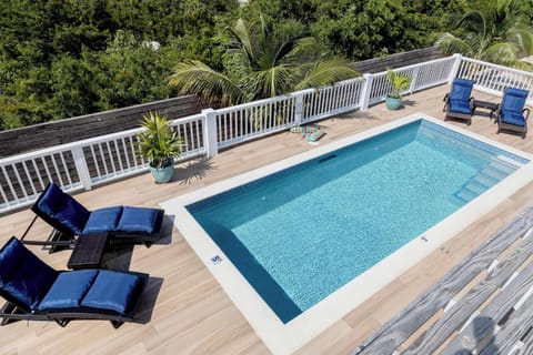A peaceful poolside with lounge chairs and plants.