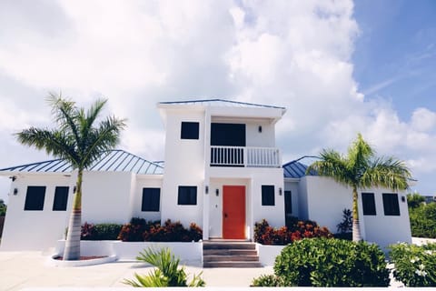 The villa's stunning, modern exterior features a crisp white facade
