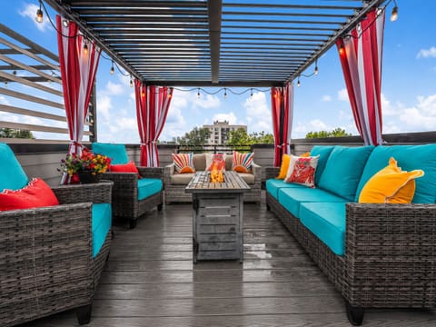 Unwind on the rooftop deck with vibrant seating, string lights, and fresh flowers—your perfect spot to relax under open skies after a day of exploring the city.