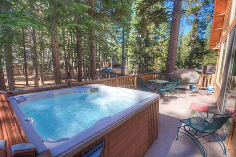 Deck with trees, sliding door, deck railing, and patio table.