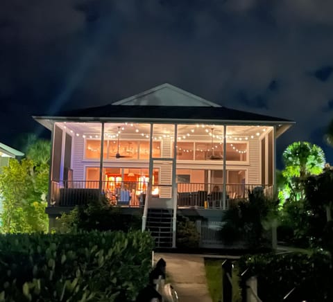 Expansive Rear Patio Finished with Glowing String Lights Overlooks the Bay
