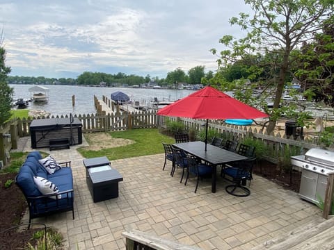Cozy outdoor living with large dining table, grill, fireplace table, hot tub.