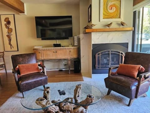 Cozy small living room with gas fireplace.  Views of the slopes from the balcony