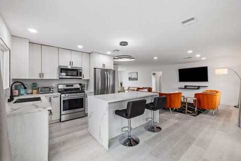 Sleek modern kitchen w/ stainless appliances, ample counter space & bar seating for casual meals.