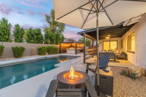 Backyard oasis featuring heated pool, hot tub, riepit and outdoor kitchen
