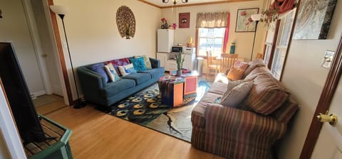 Living room has 2 full sofas, mini kitchenette, table, chairs, TV, coffee/tea