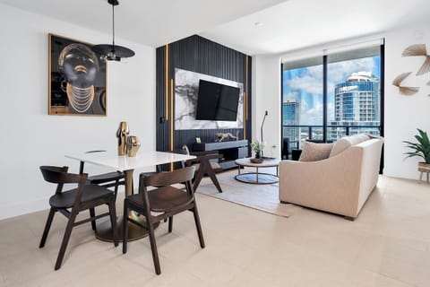 Living room with dining table for 4, queen-size sofa bed, and smart TV.
