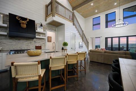 Modern rustic kitchen with island seating, open concept living area, and stunning vaulted ceilings.
