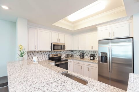 Prepare meals in this kitchen with elegant cabinetry, stainless appliances, and spacious countertops