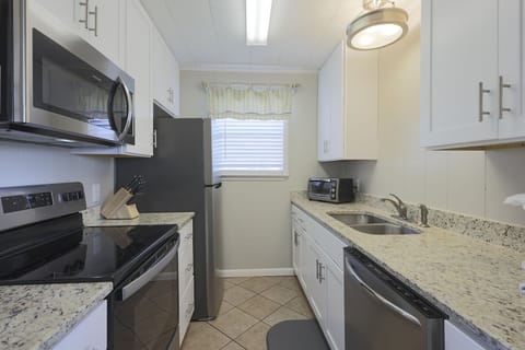 This kitchen features stainless appliances, granite countertops, and a cozy atmosphere perfect for meal preparation