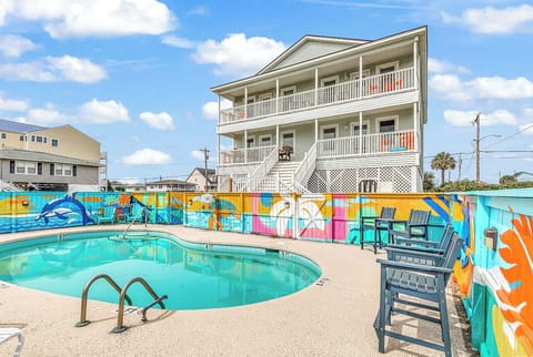 Our in-ground swimming pool, surrounded by an artist painted mural, and seating