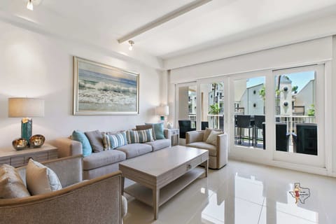 Bright, coastal-inspired living room with comfortable seating and direct access to a balcony