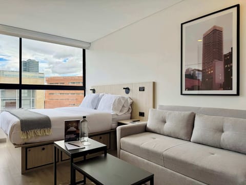 Living space with a sofa, armchair, and framed artwork.
