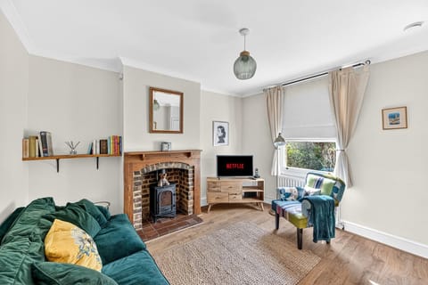 Unwind in the cozy living room, featuring a smart TV, a plush sofa, and a comfortable armchair.