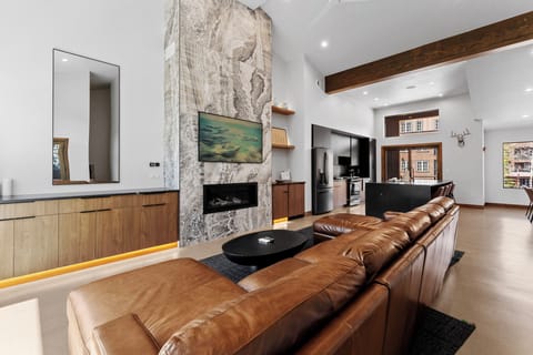 Sink into luxurious leather seating by your stunning stone fireplace, where modern elegance meets mountain charm in this thoughtfully designed space.