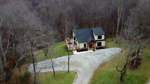 A bird’s-eye view of your secluded getaway—tucked into the woods with a spacious deck, private drive, and nothing but peaceful forest surrounding you.