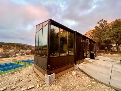 Stargazer is a modern container cabin at East Zion Resort with GLASS CIELINGS, 360 windows, mountain views, and peaceful Southern Utah scenery.