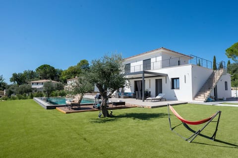 Relax in the lush garden of Villa Belletoile, featuring a hammock under an olive tree, an infinity pool, and stunning views of Provence.