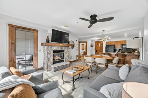 Vaulted great room with stone hearth and open kitchen.