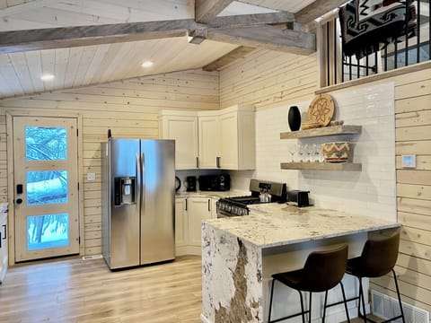 A full kitchen with granite waterfall peninsula with extra seating and gas range