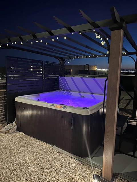 Relax in a private 5-person hot tub nestled under a pergola in the backyard