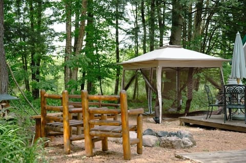 Fire ring, log seating and gazebo with bug netting. All firewood for the outdoor firepit is provided and located by the trees under a sheet of tin roofing. 