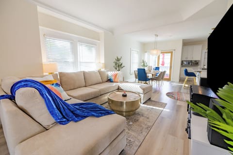 A living room with modern beige sofa with pastel pillows invites relaxation.